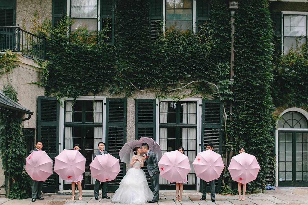 Bride, groom and their wedding party with pink umbrellas, their favours to their guests. To see more, visit Rebecca Chan Weddings and Events https://rebeccachan.ca