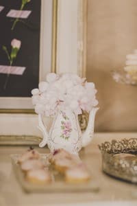 Flowers in a vintage creamer cup and profiteroles. Coral and Gold Wedding Inspiration - See more at Rebecca Chan Weddings and Events rebeccachan.ca