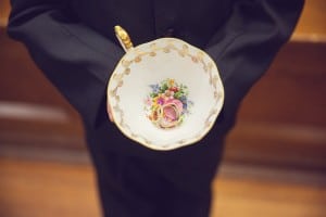 Elegant vintage-inspired purple and gold wedding - Ring boy holding rings in a tea cup
