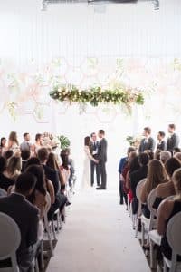 Modern Industrial Wedding Ceremony with Wall Vinyl and Hanging String Lights at District28