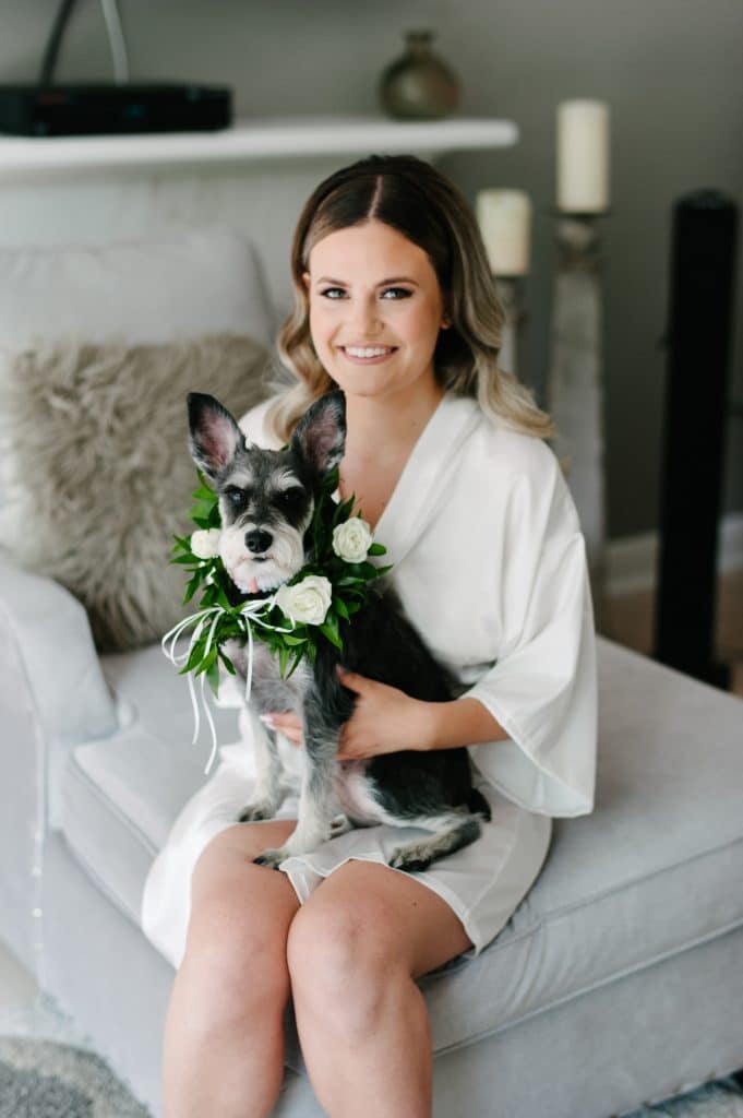 Bride with her dog, wearing a floral garland.