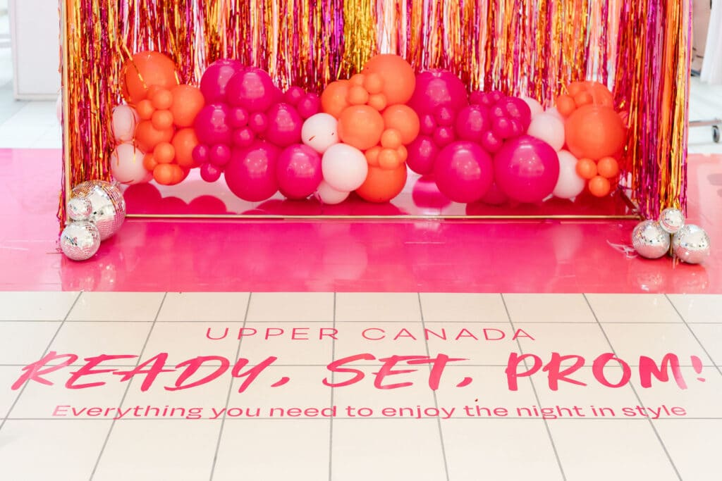 Custom made pink and orange fringe backdrop with disco balls and balloons - Prom pop up at Upper Canada Mall